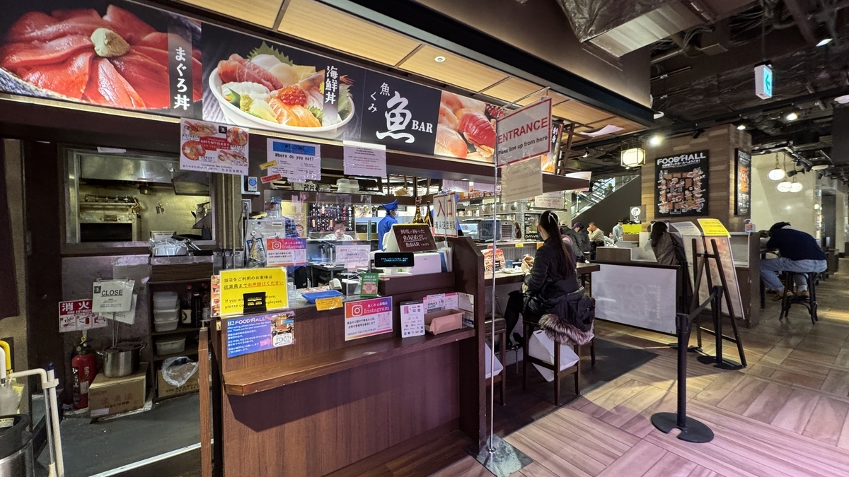 鮮魚店直営の魚BARカウンターと海鮮丼メニュー看板