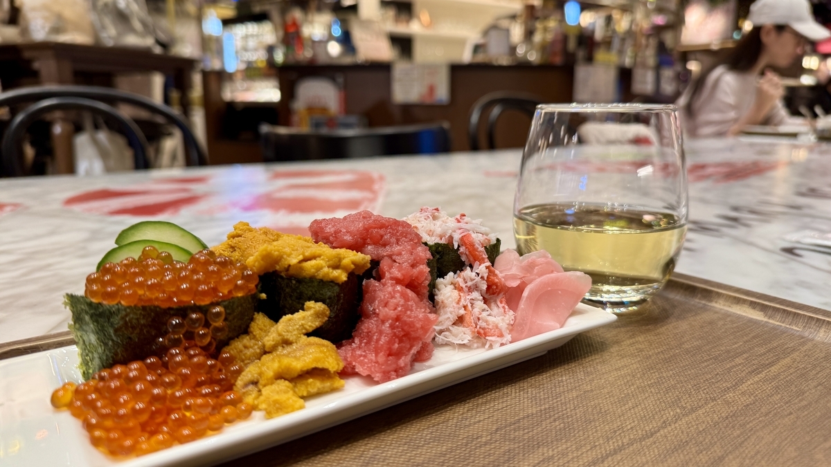 こぼれ軍艦と白ワインを並べた共有席での実食風景