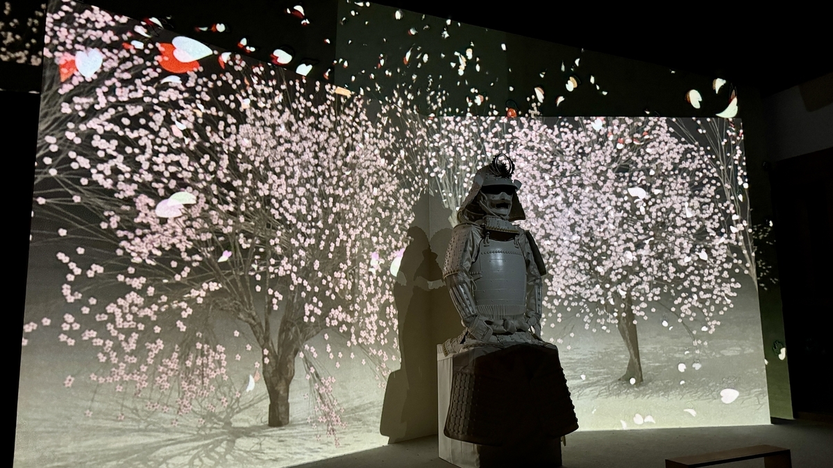 桜吹雪の映像に包まれる白い甲冑