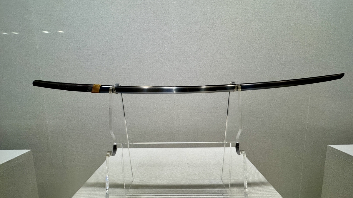 透明な台座に置かれた反りの深い日本刀