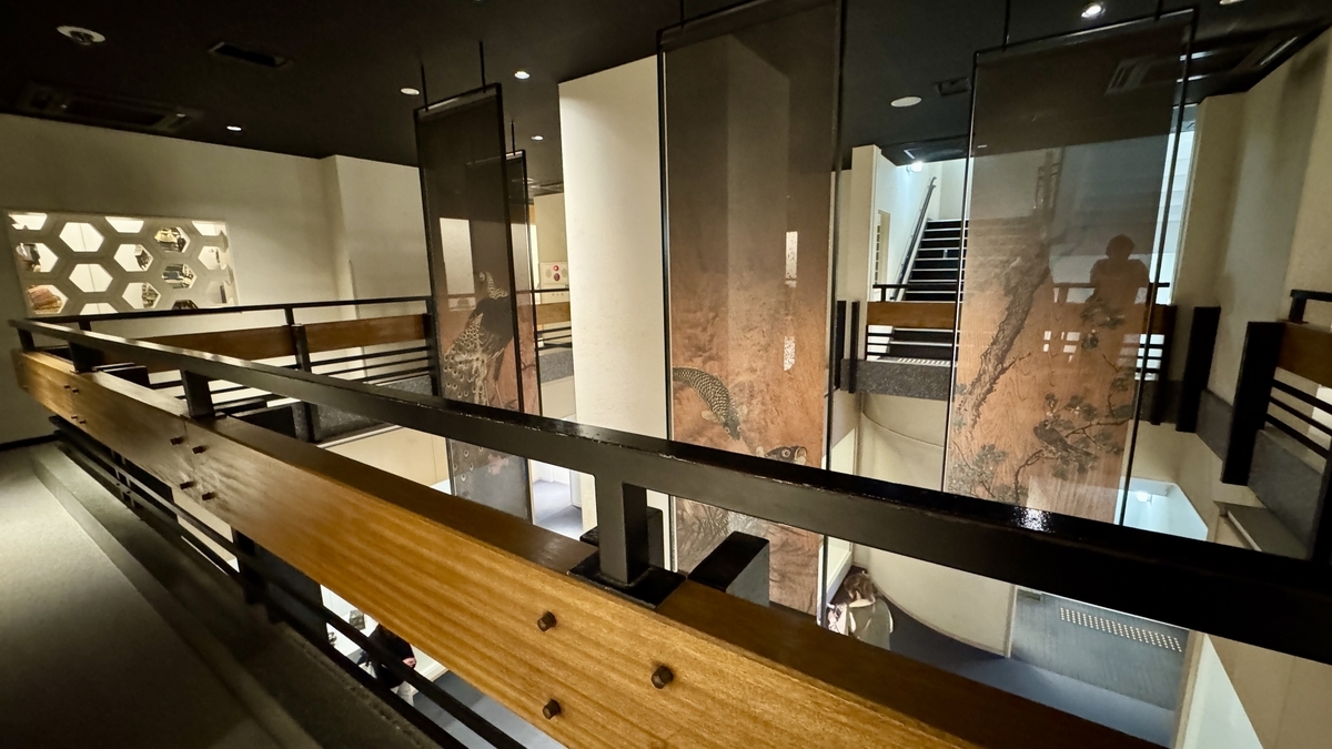 吹き抜けに屏風絵が吊られた4階展示フロア