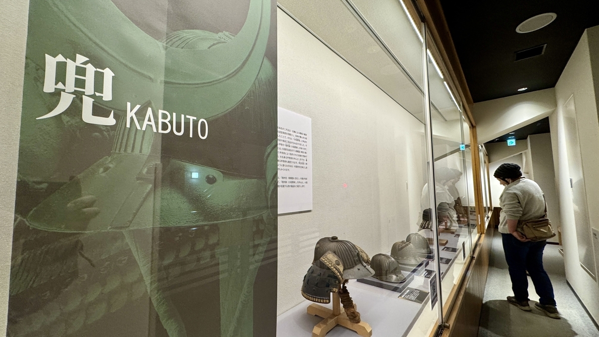 兜展示コーナーの案内パネルと並ぶ変わり兜