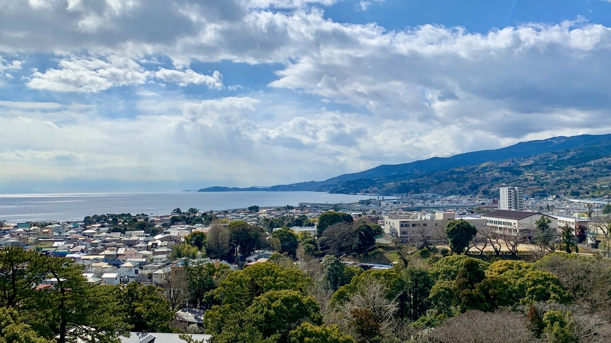 雲間の光が差す相模湾と海沿いの町並み