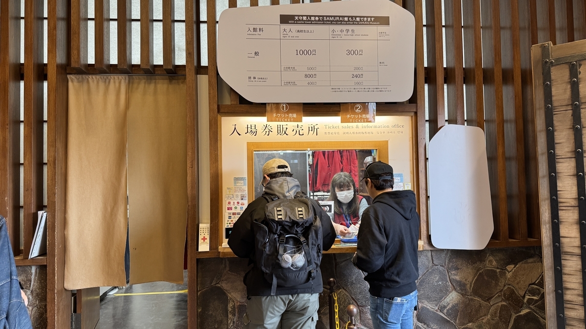 天守閣の入場券販売所でチケットを買う来館者