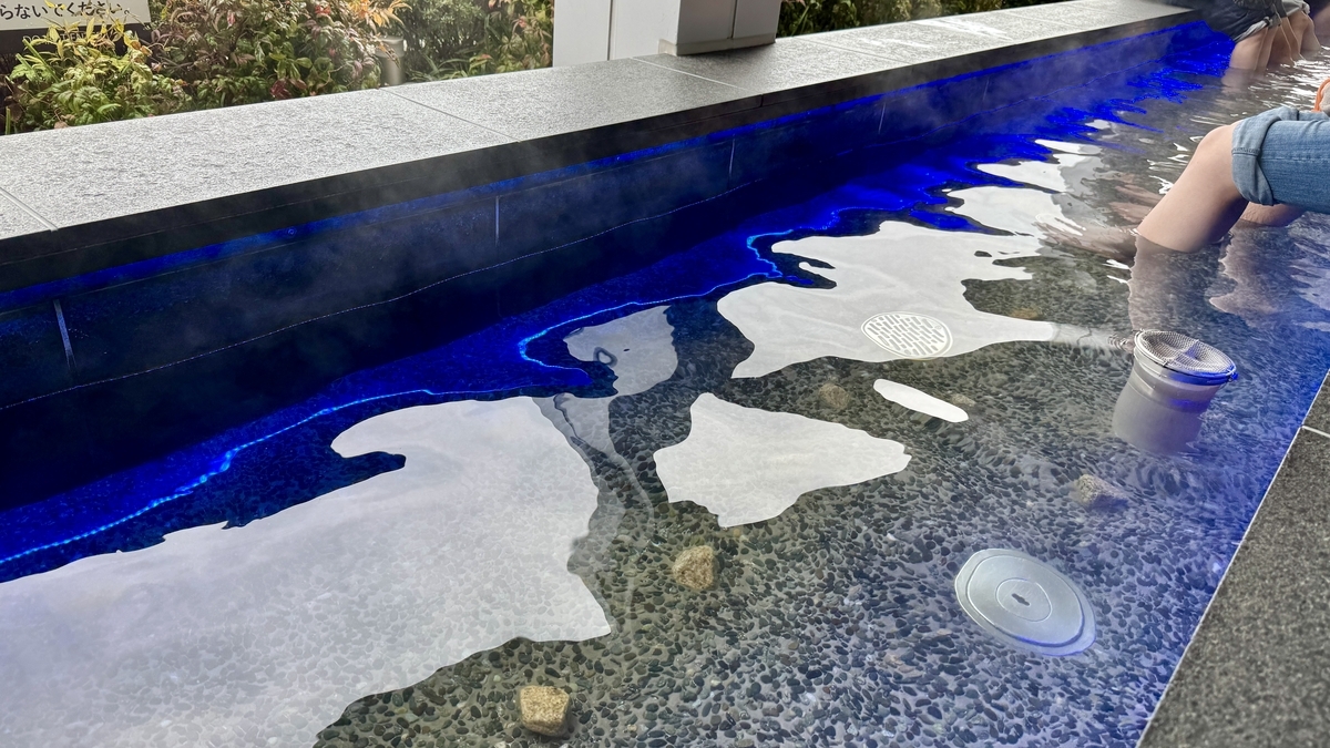 ผิวน้ำในอ่างแช่เท้ากับขอบไฟสีฟ้าและก้อนหินสำหรับฝ่าเท้า