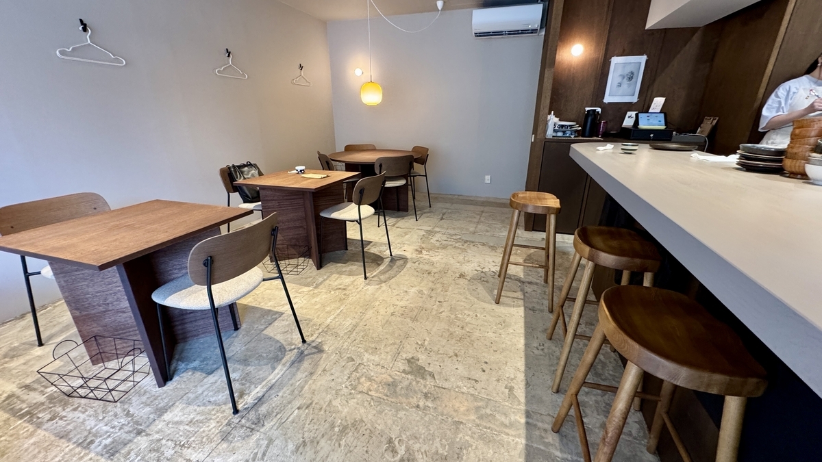 Wooden tables and counter seats lining the interior of Komejirushi