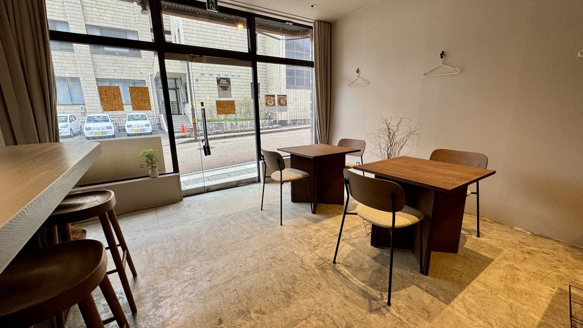 Sunlit table seats by the large windows at Komejirushi