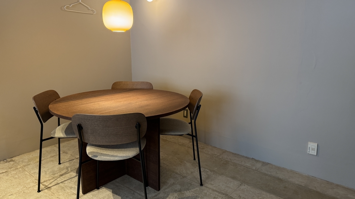 A round table under a pendant light at Komejirushi