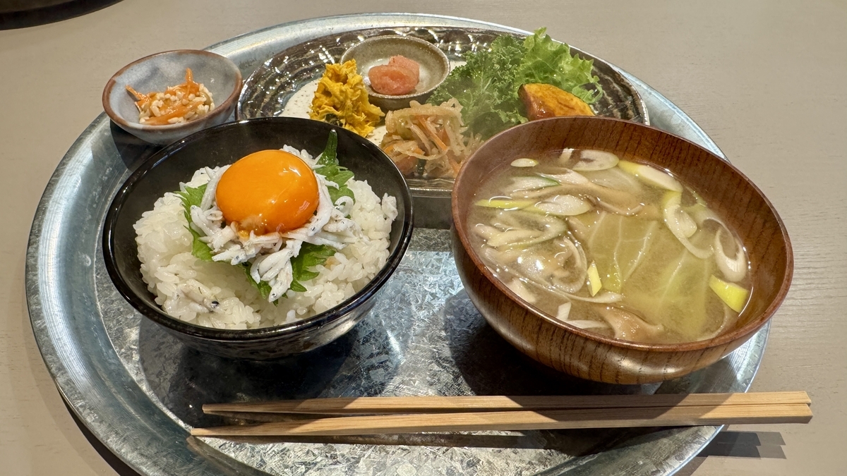 An Asagohan set with shirasu and egg yolk over rice, miso soup, and small side dishes