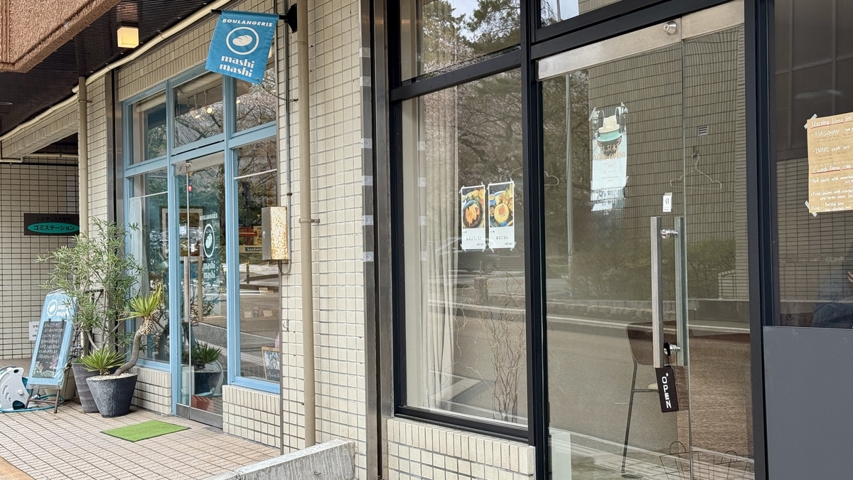 The Komejirushi entrance next to a bakery with a blue sign