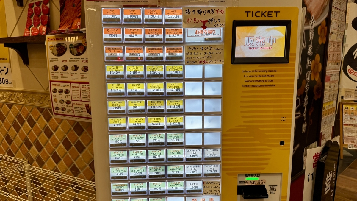 Máquina expendedora de tickets en el local con opciones de katsu curry por tamaño y topping
