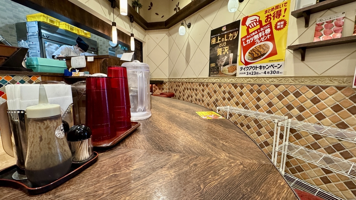 Asientos de barra de Champion’s Curry Sucursal Omicho con condimentos y servicio de agua
