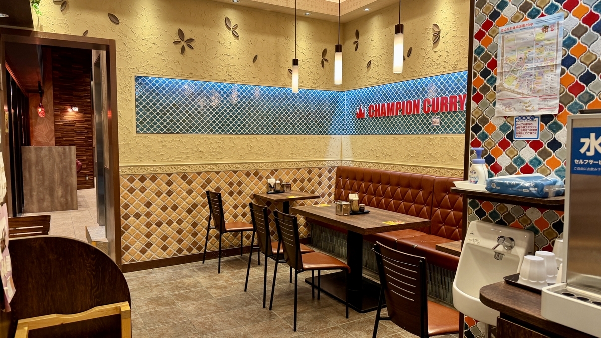 Zona de mesas con decoración de azulejos con el logo y luz cálida