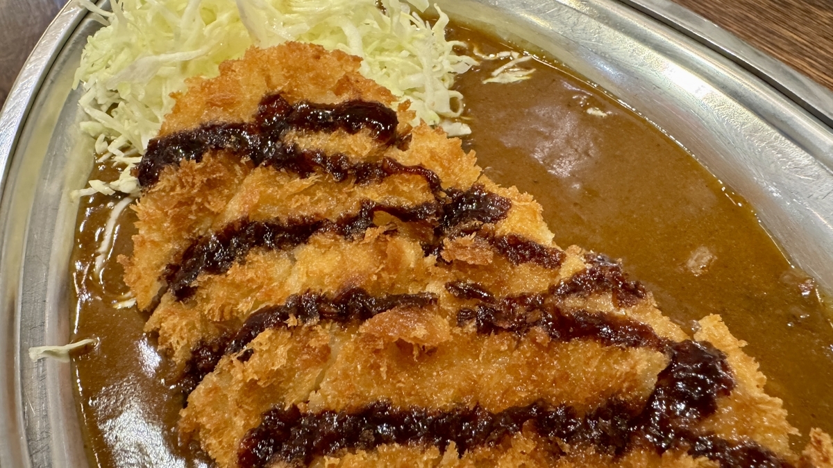Primer plano del L-Katsu Curry con salsa y col en juliana