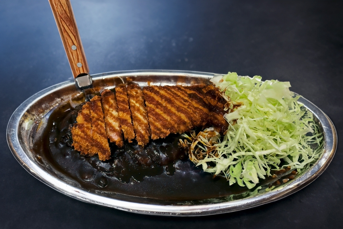 Curry de Kanazawa con cutlet y col rallada en un plato de acero inoxidable