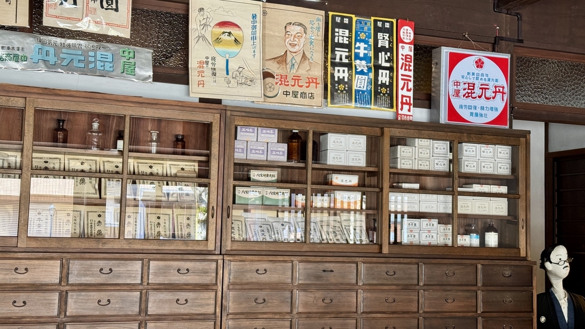 中屋药铺药架上排列的药盒与昔日广告招牌