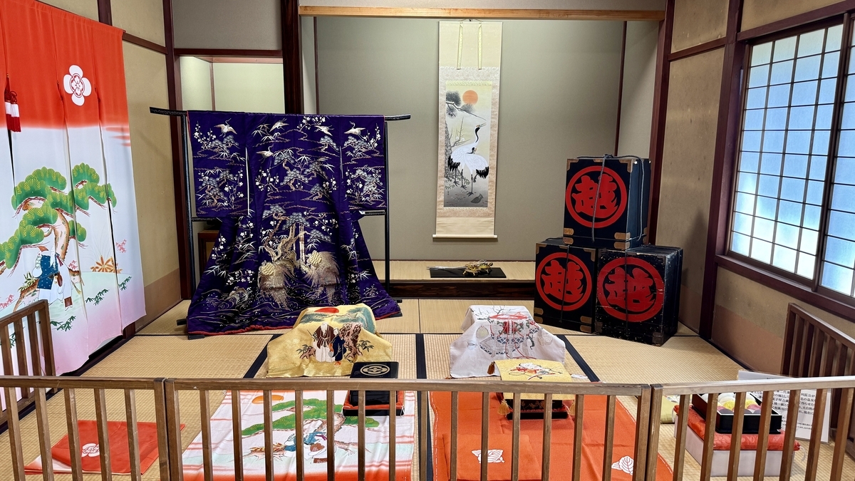 花嫁衣装与花嫁暖帘并列陈设的婚礼文化展厅