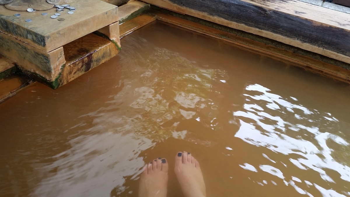Brown-colored hot spring foot bath framed in wood