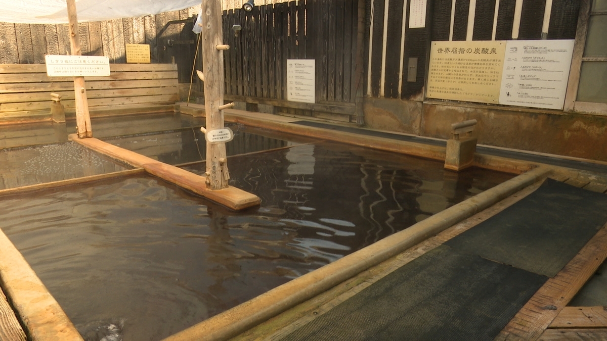 Wood-framed bathtub filled with carbonated spring water at Nagayu Onsen