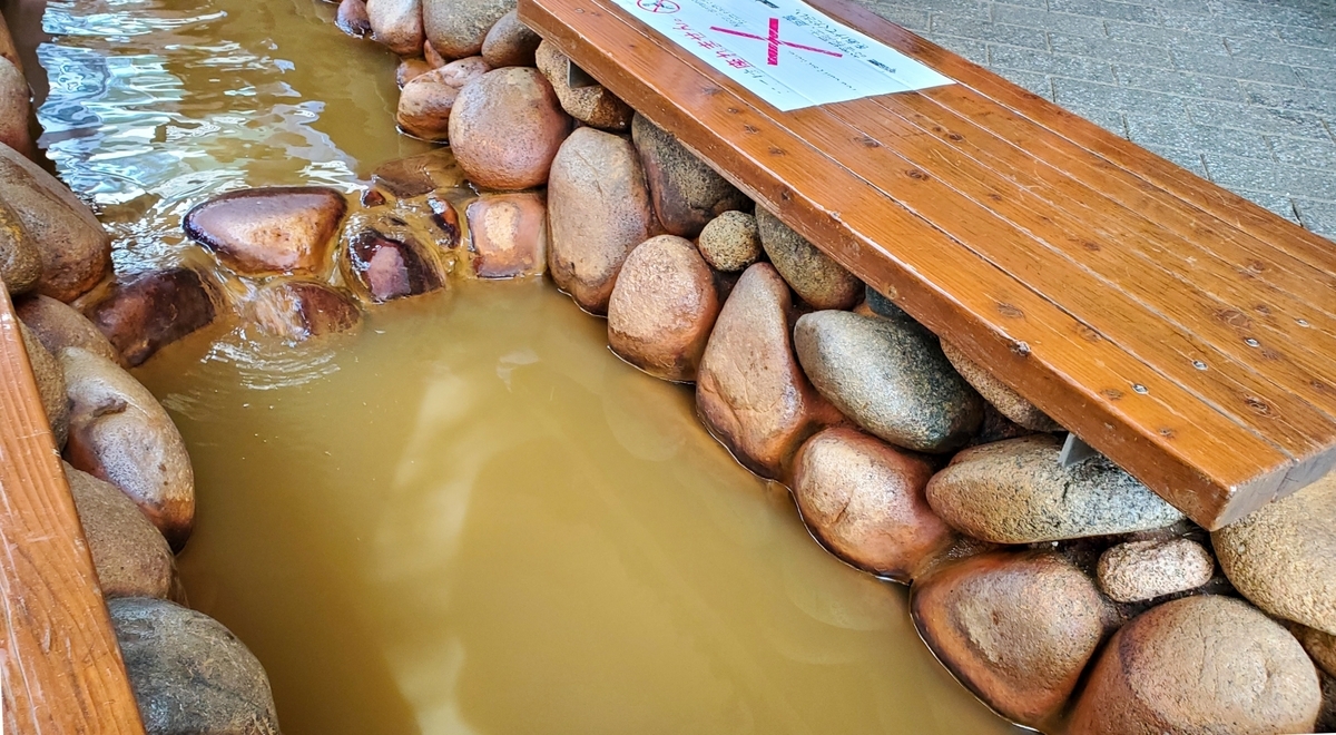 Stone foot bath filled with golden-colored hot spring water