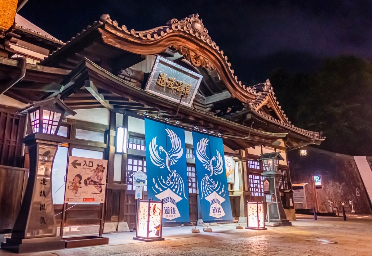 La entrada del edificio principal de Dogo Onsen iluminada de noche