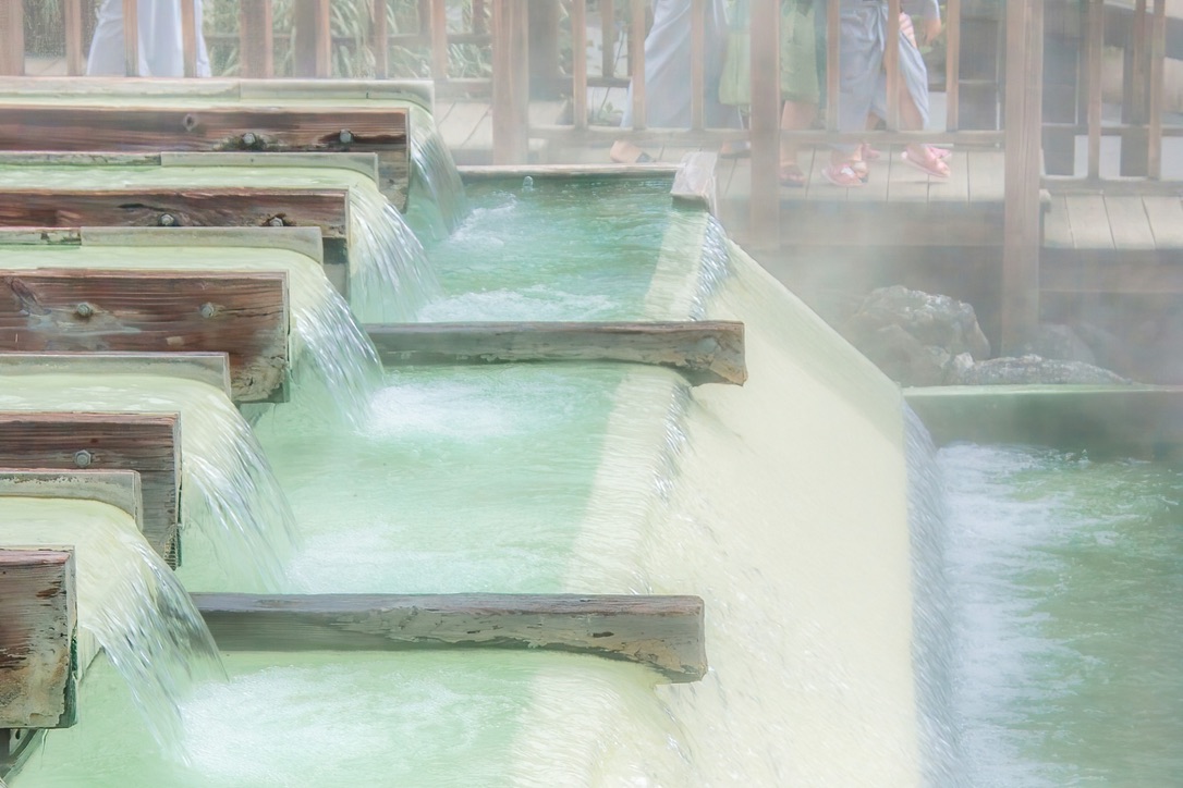 El agua de manantial de un blanco lechoso fluyendo por el yubatake de Kusatsu Onsen
