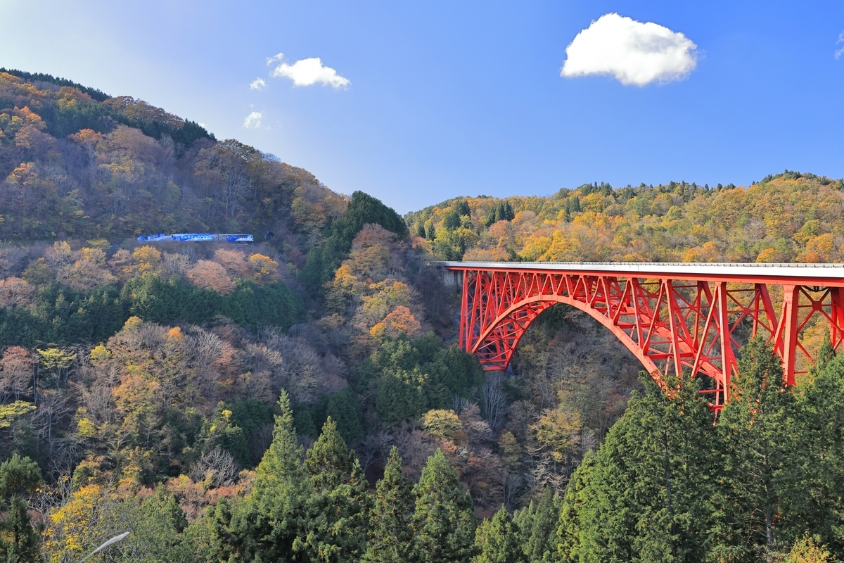 Un puente rojo que cruza las montañas de Okuizumo y un bosque otoñal