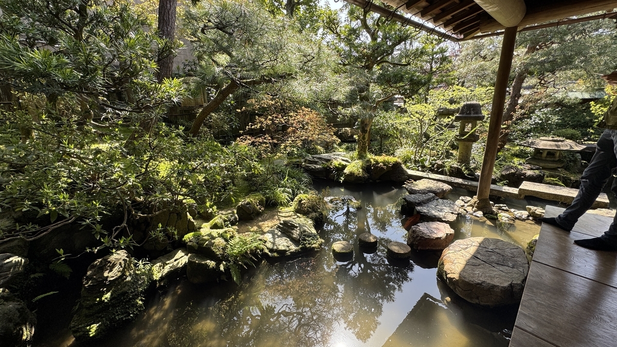 縁側から眺める野村家の曲水と石灯籠の庭園