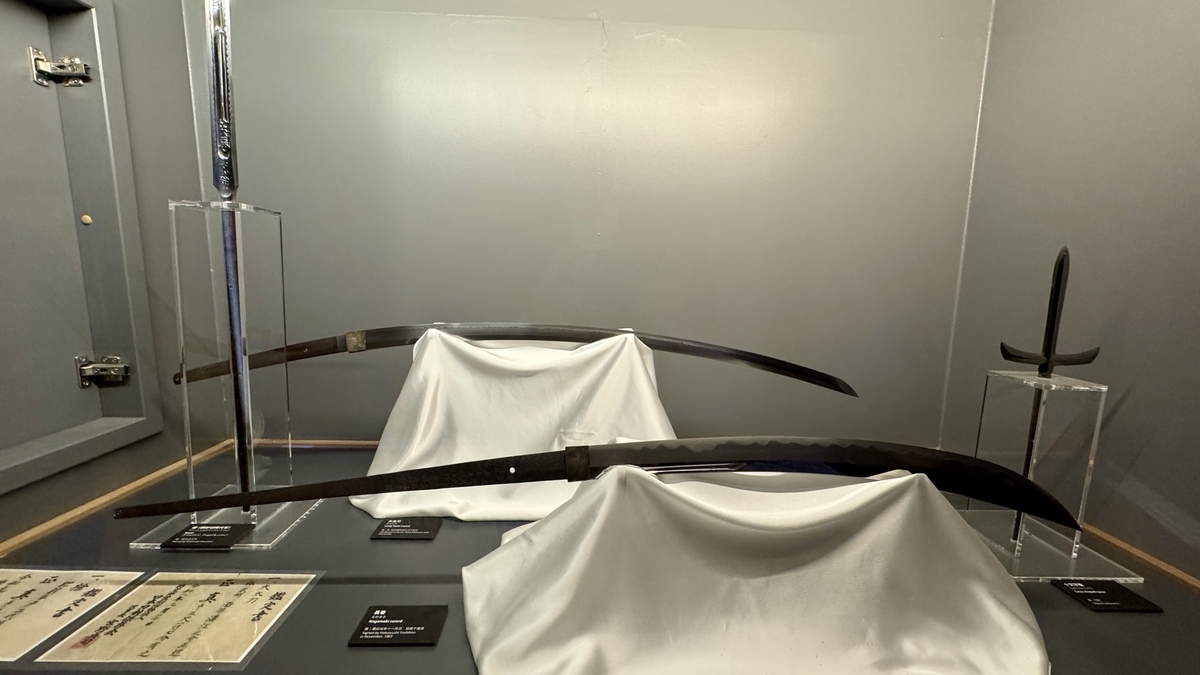 A display case lined with naginata and short swords
