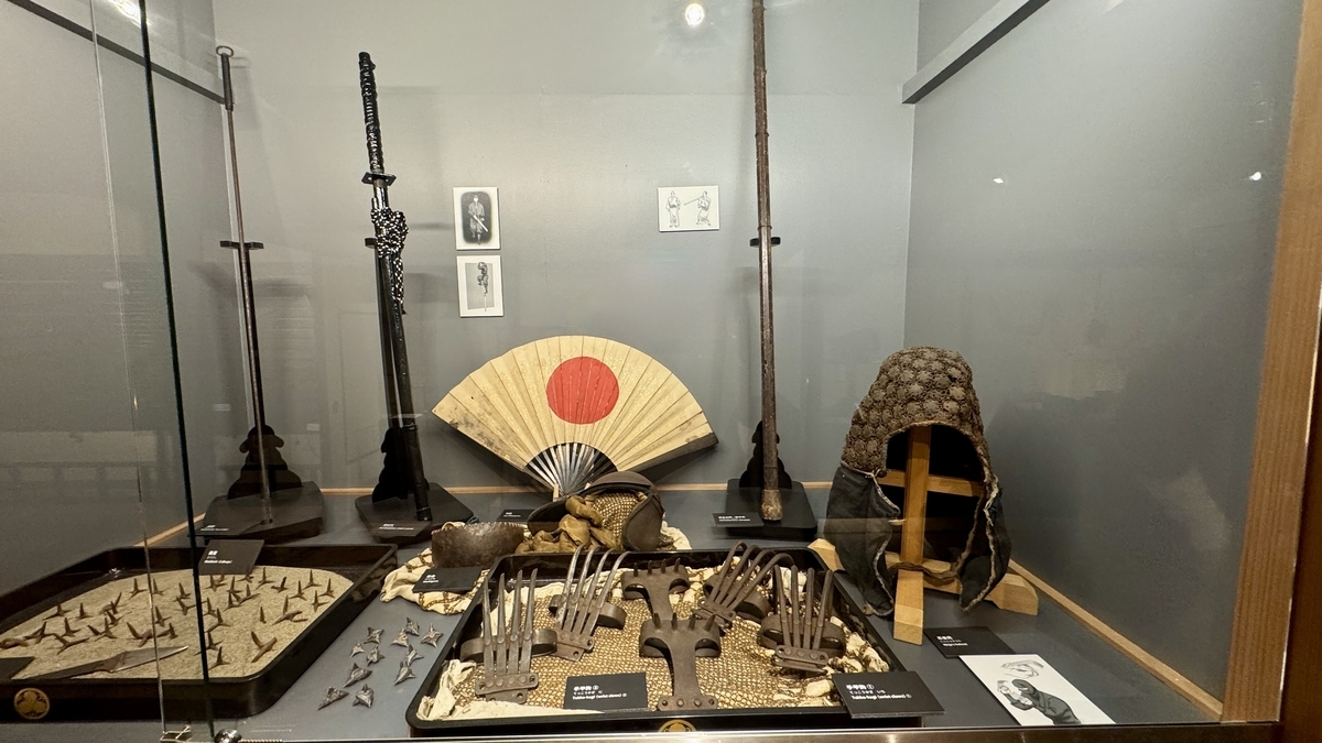 A display of ninja tools lined with caltrops, shuriken, and hand claws