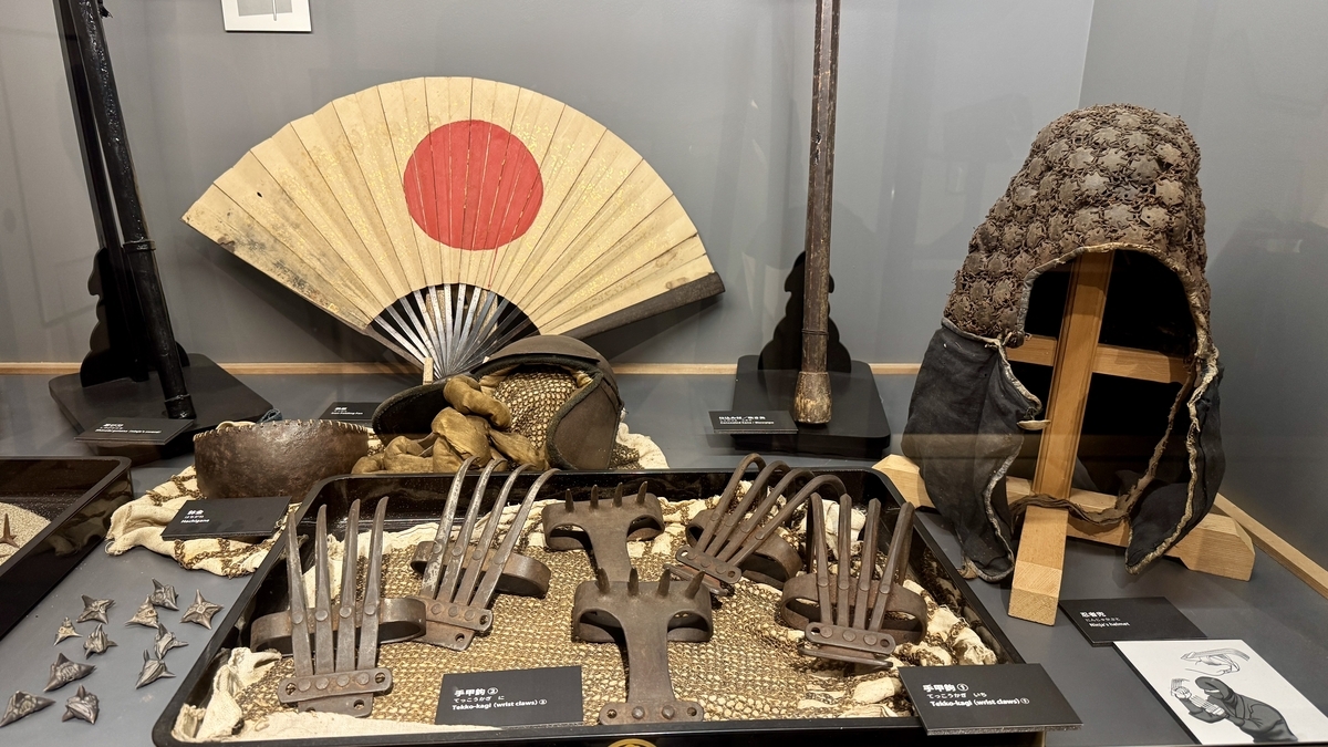 A display where hand claws and a ninja helmet can be seen up close