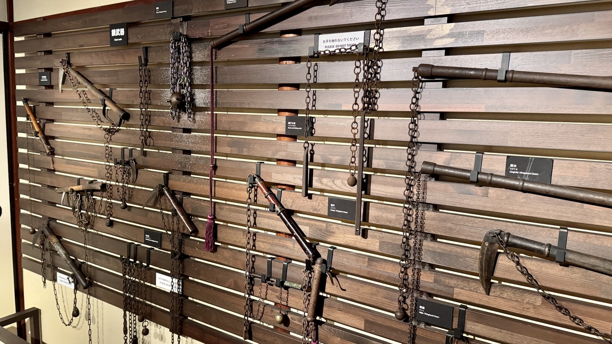 A wall display hung with weighted chains and kusarigama