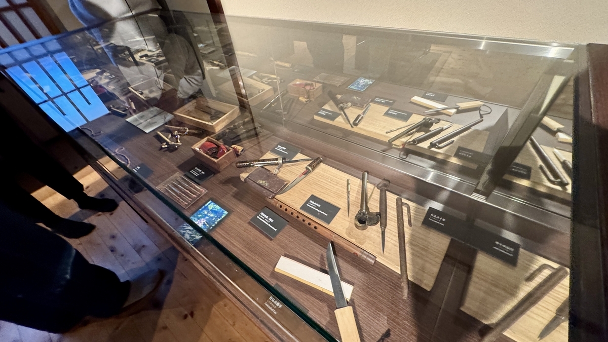 A display case lined with ninja sickles and concealed tools