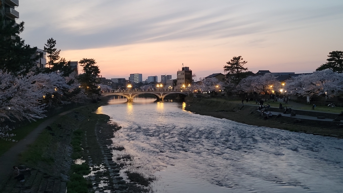 The Asano River at dusk with lights glowing on the bridge