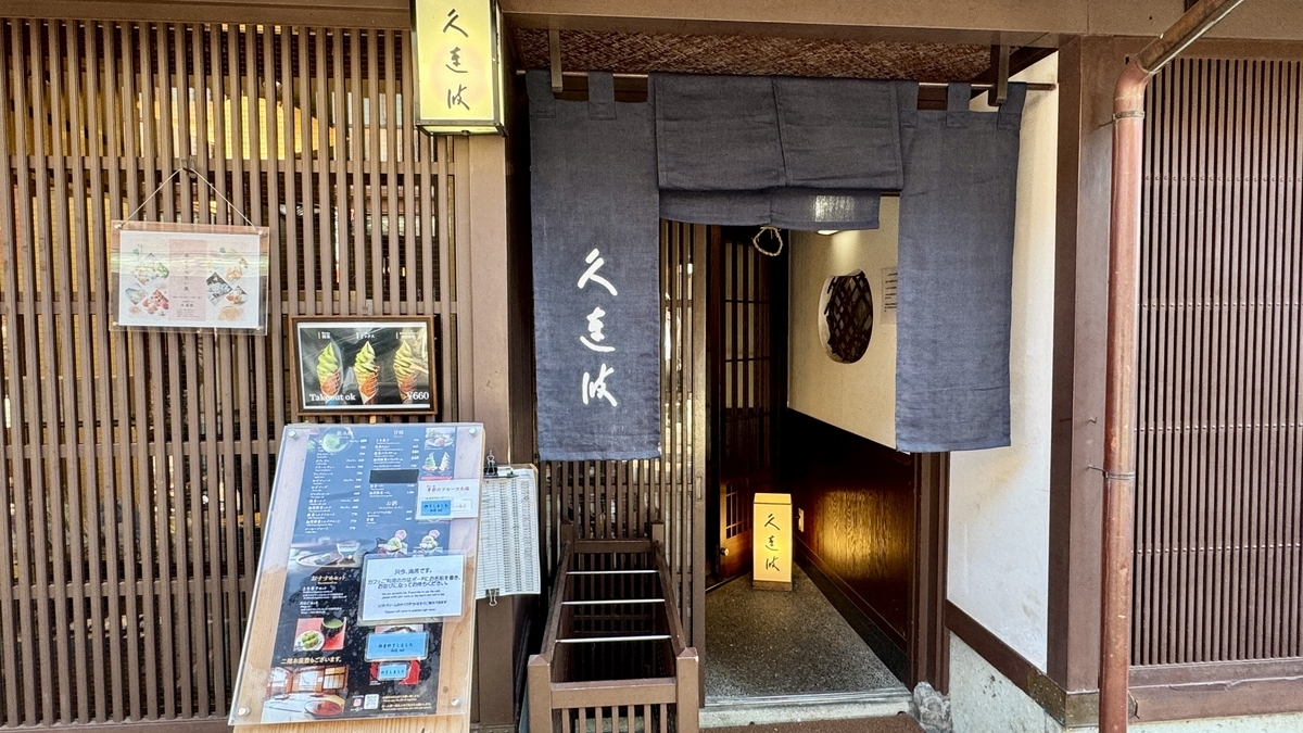 El escaparate de un comercio del barrio Higashi Chaya con una puerta de celosía y una cortina noren