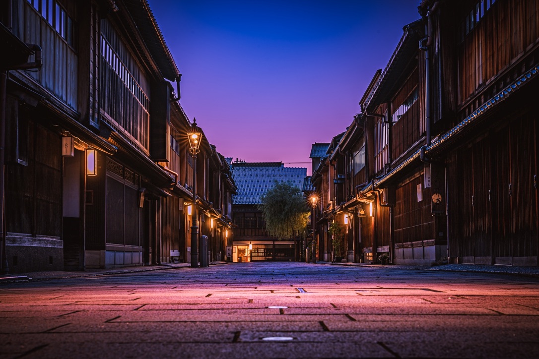 El barrio Higashi Chaya de noche, con farolas iluminando el empedrado bajo un cielo violeta