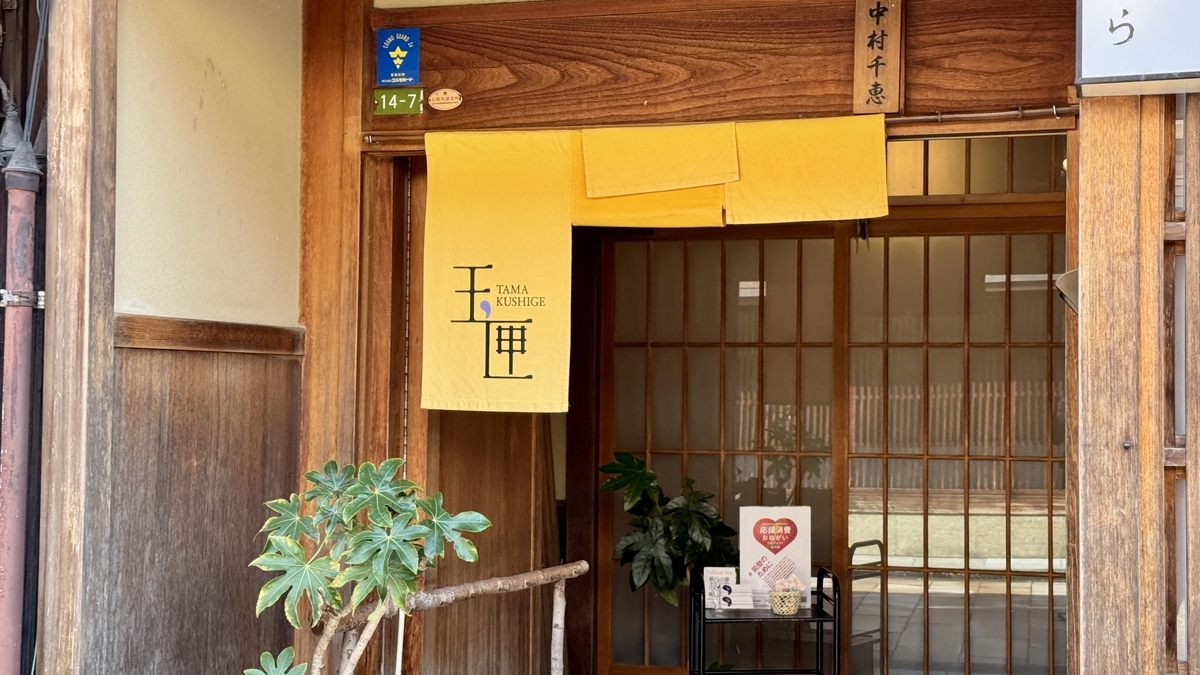 La entrada de Tamakushige con una cortina noren amarilla