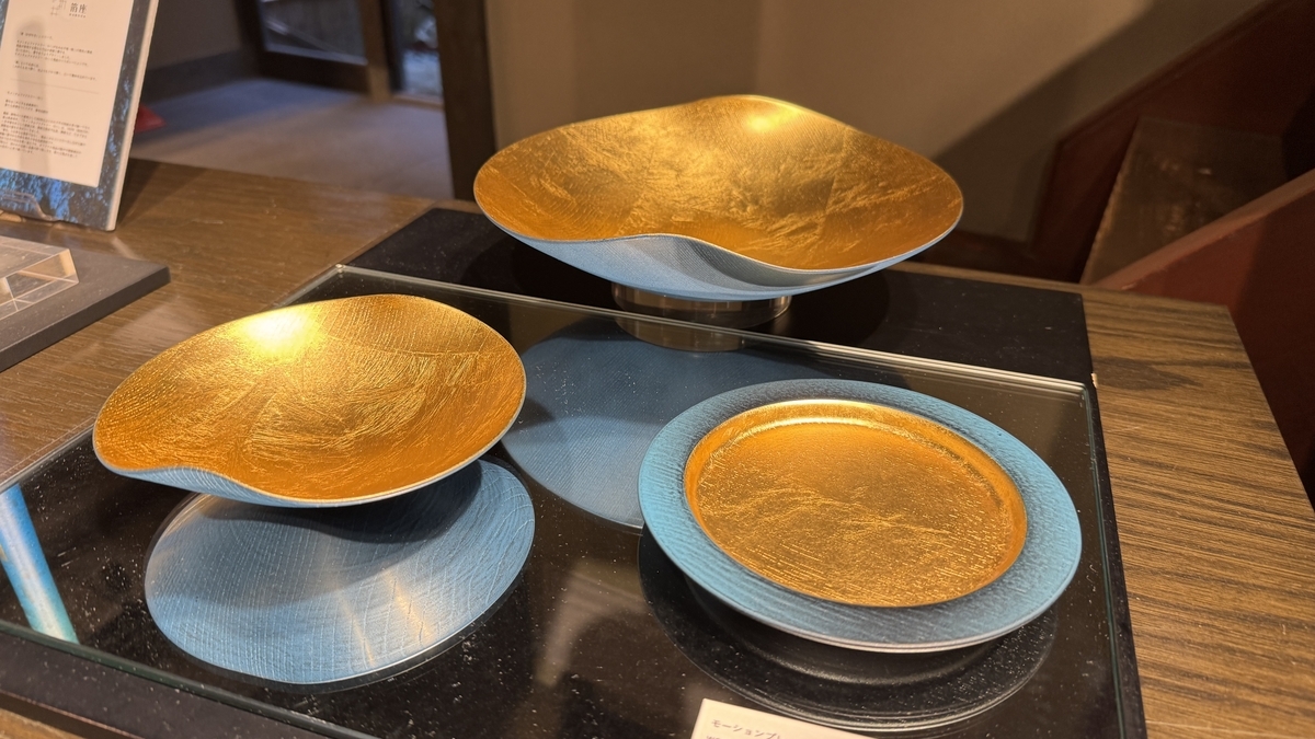 Un recipiente azul con pan de oro brillando en su interior, en exposición