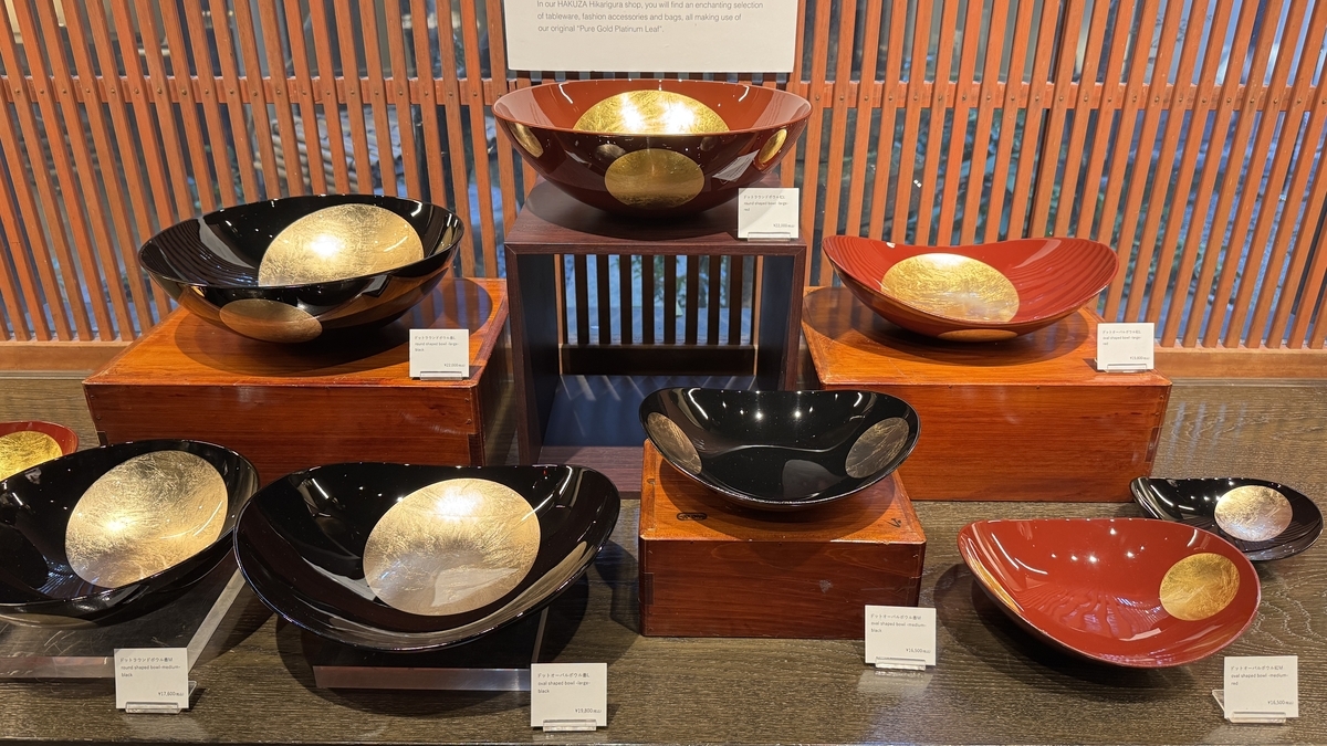 Recipientes de laca negra y bermellón decorados con pan de oro, en exposición