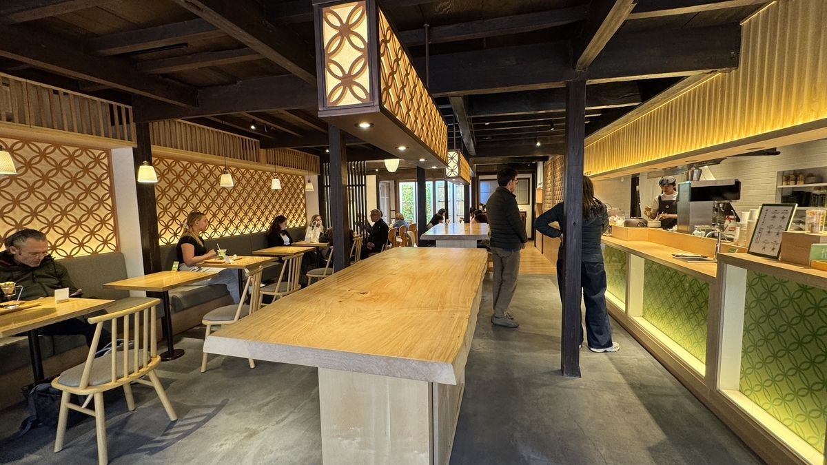 El interior de estilo japonés moderno de Maccha House con una gran mesa de madera y asientos