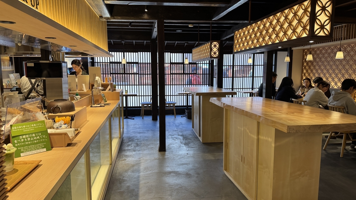 Asientos en Maccha House con una ventana de celosía y una barra de madera