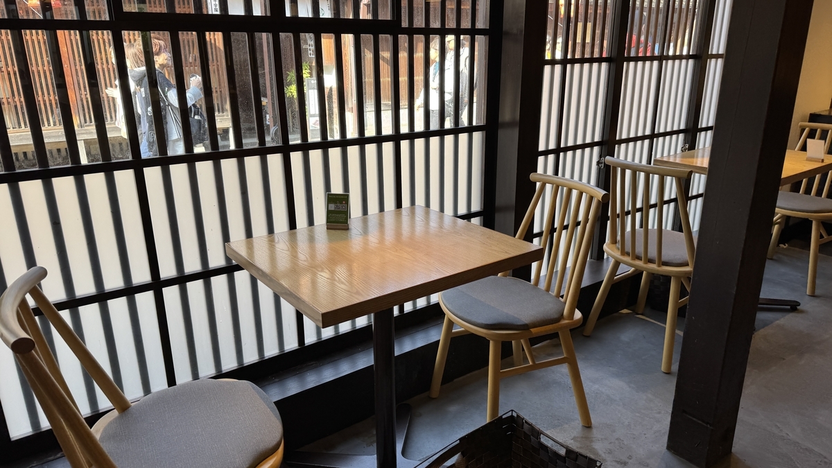 Una mesa en Maccha House con vistas a la calle a través de una ventana de celosía