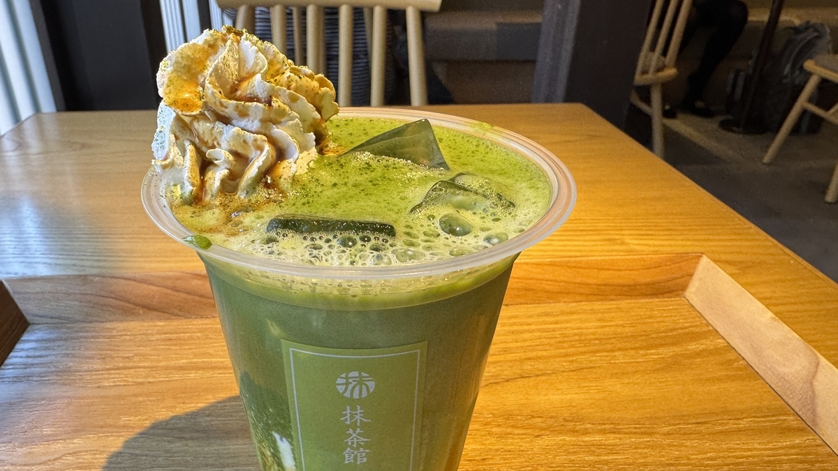 Un latte de matcha con kuromitsu coronado con nata montada en Maccha House