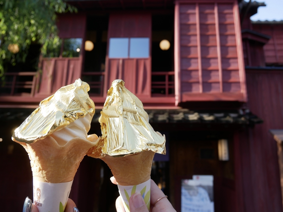 Una mano sosteniendo un helado soft coronado con pan de oro en el barrio Higashi Chaya